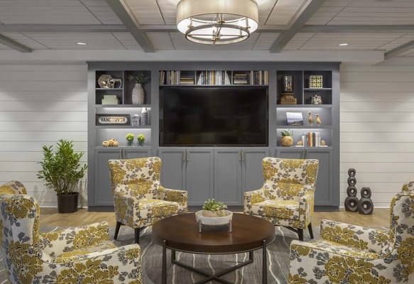 Seating area with floral chairs and a large television