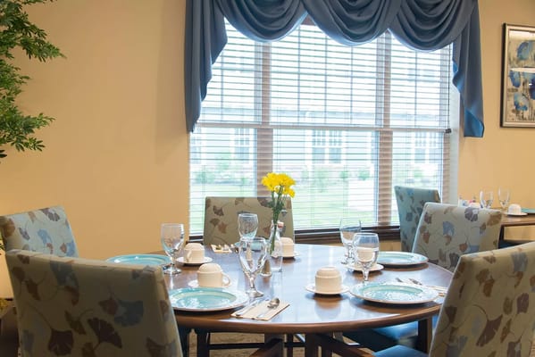 Dining room setup with dishes and flowers.
