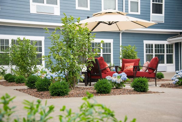 Outdoor seating area with red furniture and greenery