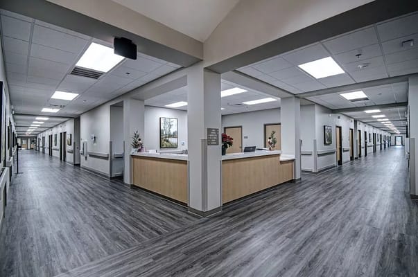 Spacious lobby with a reception desk and hallways in Trend Health and Rehab