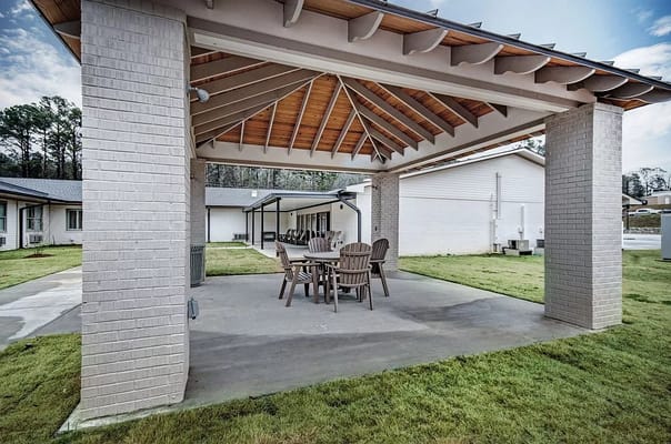 Outdoor seating area with wooden chairs under a roof