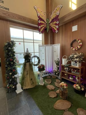 A decorative area featuring a large butterfly and floral arrangements at Trouvaille Memory Care Suites.