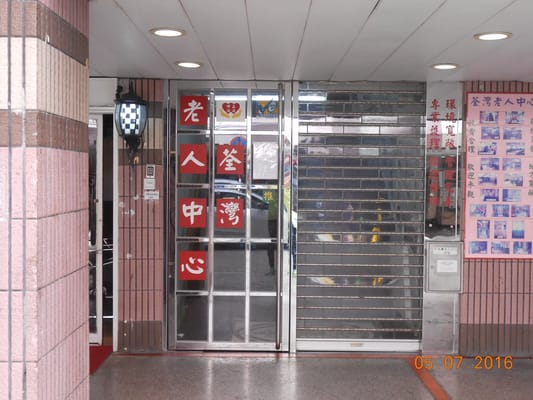 The entrance door of Tsui Wan Nursing Home, with signage in red.