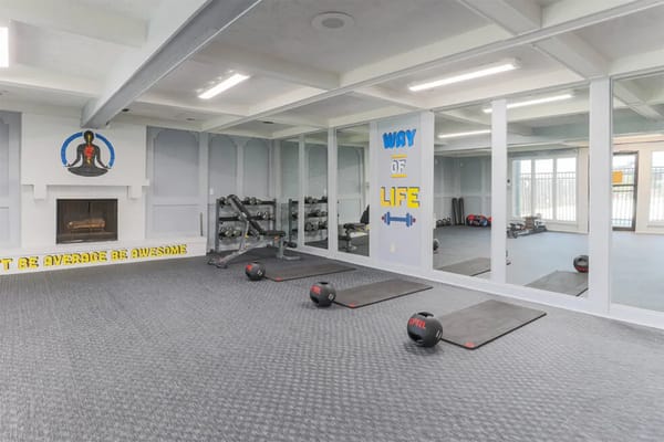 Spacious gym with weights and exercise mats