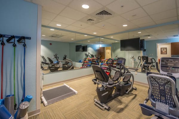 Well-equipped fitness room with exercise machines and weights