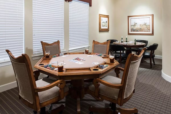 A gaming table with chairs and drinks in a well-lit room.