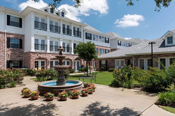 Fountain surrounded by flower beds at Twin Rivers Senior Living