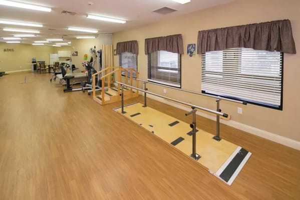 Interior view of therapy room with equipment and wooden railing