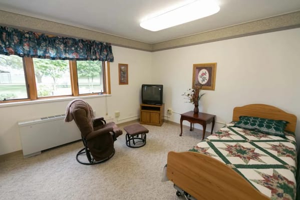 Cozy resident room with a single bed and chair