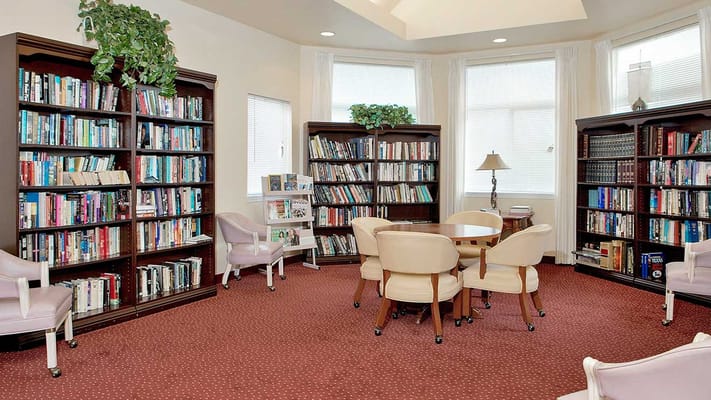 A cozy library reading area with bookshelves and seating.