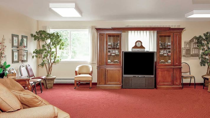 Living room with comfortable seating, entertainment center, and large window