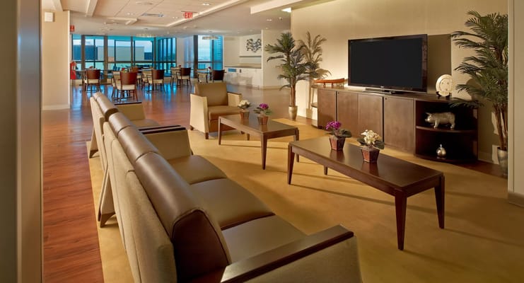 Lounge area with seating and small tables in rehabilitation center