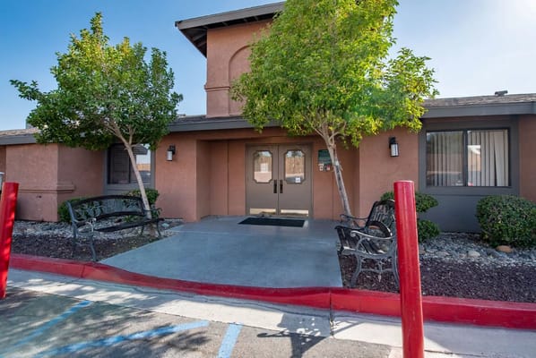 Front entrance of Valley Crest Memory Care facility with benches and landscaping