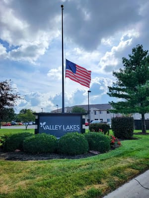 Entrance sign of Valley Lakes with American flag flying