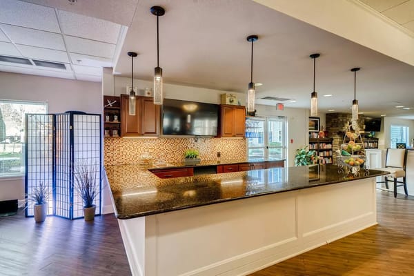 Bright kitchen area with a granite countertop and seating