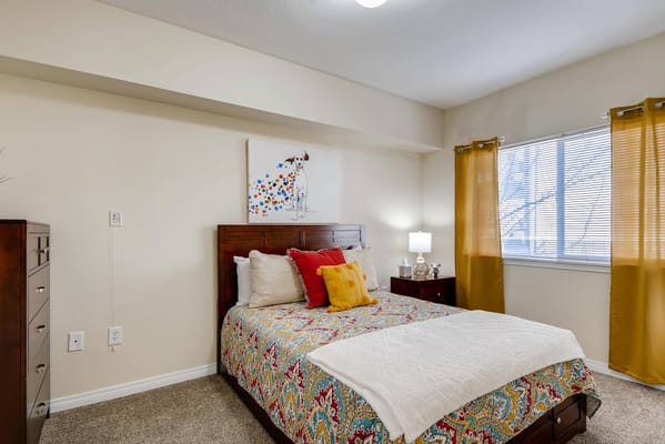 Stylish bedroom with colorful bedding and window curtains