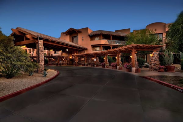 Main entrance with a covered driveway and landscaping at Vi at Grayhawk.