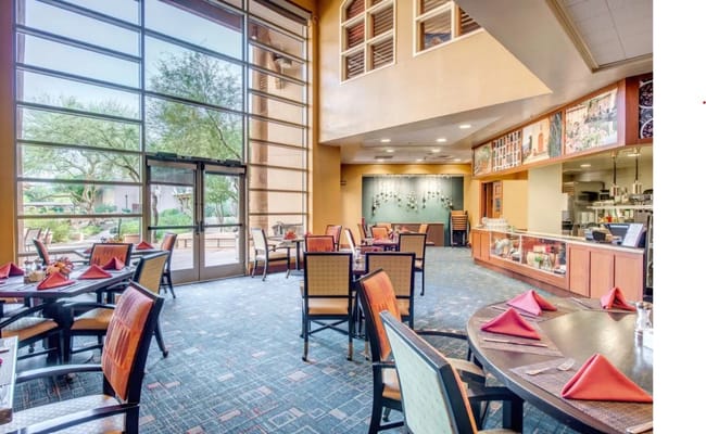 Bright and spacious dining room with tables set for dining