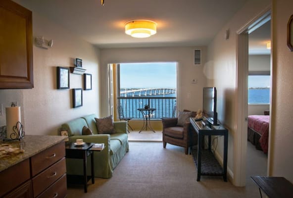 Living room featuring a green sofa, television, and a view of the water