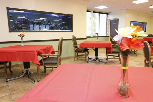 Dining area with red tables and an aquarium