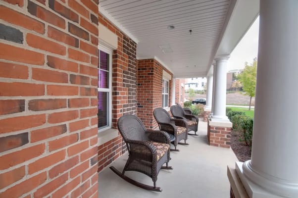 Porch with rocking chairs at Victory Court Senior Apartments