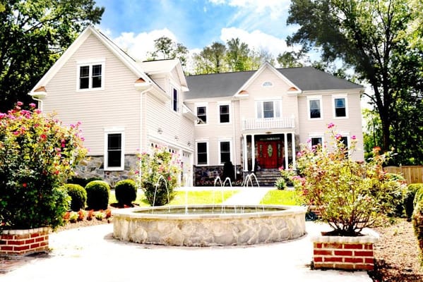 Exterior view of Vienna Manor Assisted Living with a fountain