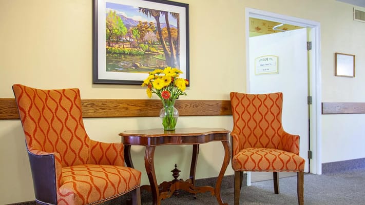 Two patterned chairs and a table with flowers in a cozy corner