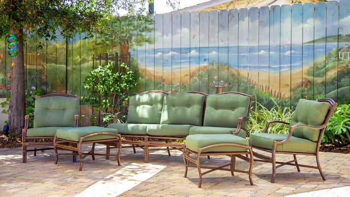 Green outdoor seating set near a mural of the beach
