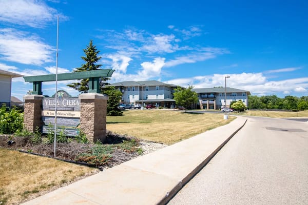 Entrance sign of Villa Ciera Senior Apartments with buildings in the background