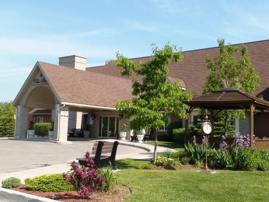 Front entrance of Villa Italia Retirement Residence with a gazebo and landscaped garden.