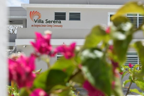 Villa Serena building sign partially obscured by flowers