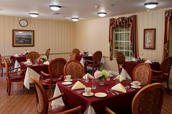 Dining room set for a meal with flowers and table settings