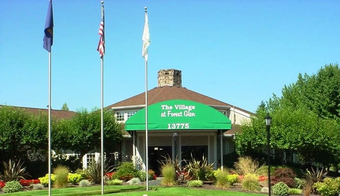 Front entrance of Village at Forest Glen with flags