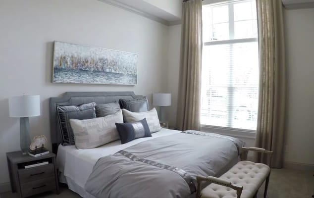 Stylish bedroom featuring a bed with decorative pillows and large window