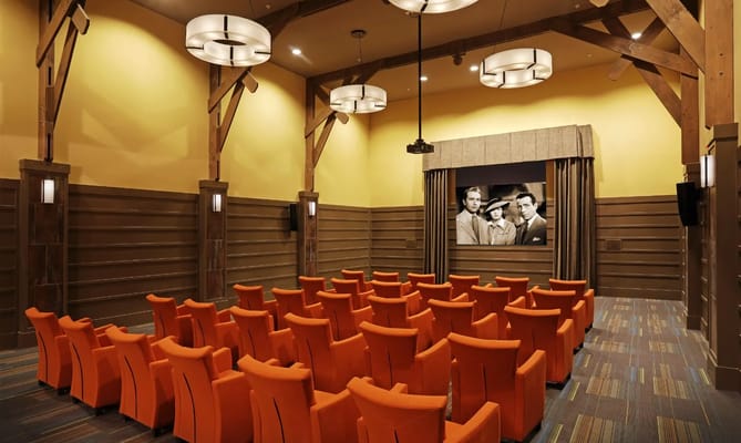 Interior view of a cozy movie theater with bright orange seating
