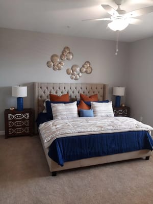 Elegant bedroom with a tufted bed, decorative pillows, and lights