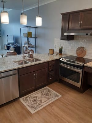 Spacious kitchen featuring dark cabinets, granite countertops, and stainless steel appliances.