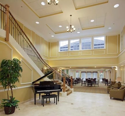 Spacious lobby featuring a grand piano and stairs