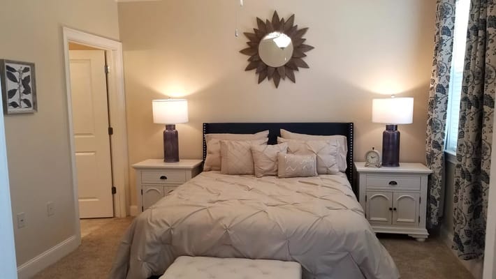 A cozy bedroom featuring a neatly made bed and bedside lamps.