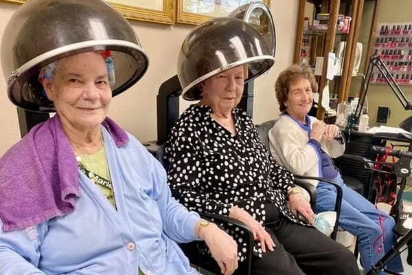 Three senior women enjoying a salon day under hairdryers.