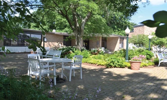 Seating area surrounded by lush greenery in Vincentian Home's garden