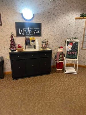 Decorative welcome area with sign, drinks, and festive decor.