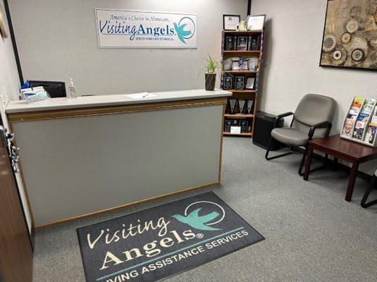 Reception desk at Visiting Angels with brochures and awards on display