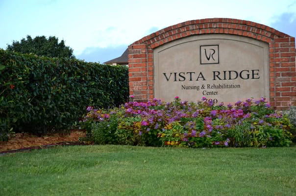 Sign for Vista Ridge Nursing and Rehabilitation Center surrounded by flowers