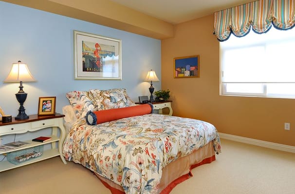 A comfortable bedroom with floral bedding and lamps