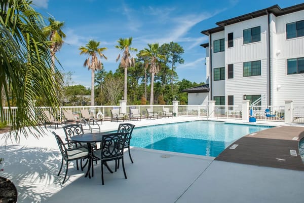 Outdoor pool area with seating and palm trees