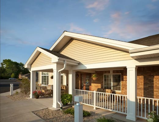 Front entrance of Waterford Senior Living with seating area and garden