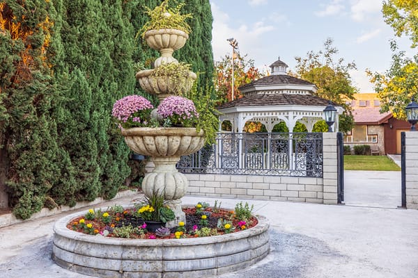 Elegant outdoor fountain surrounded by greenery and gazebo