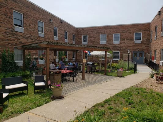 Residents enjoying an outdoor space with seating and tables