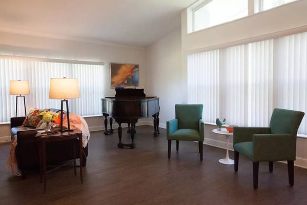 Bright interior common area with a piano